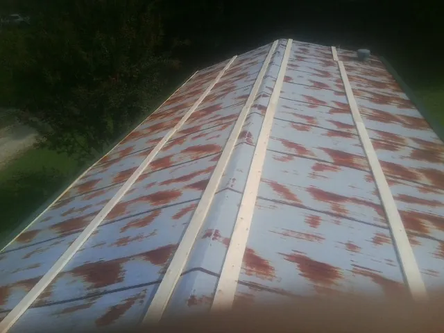 Rusted metal roof panels with new wood purlins before replacement — Storm Damage Roof Repair in Craigville by Roofing Brothers